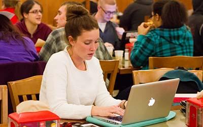 Bryn Athyn College student writing on a laptop