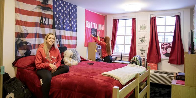 Students hanging out and decorating their room in one of the comfortable residence halls
