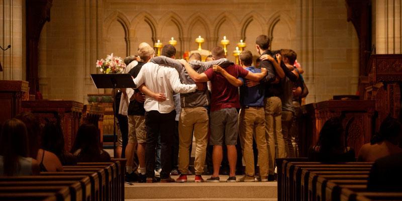 Students huddle together at the alter during a blessing service